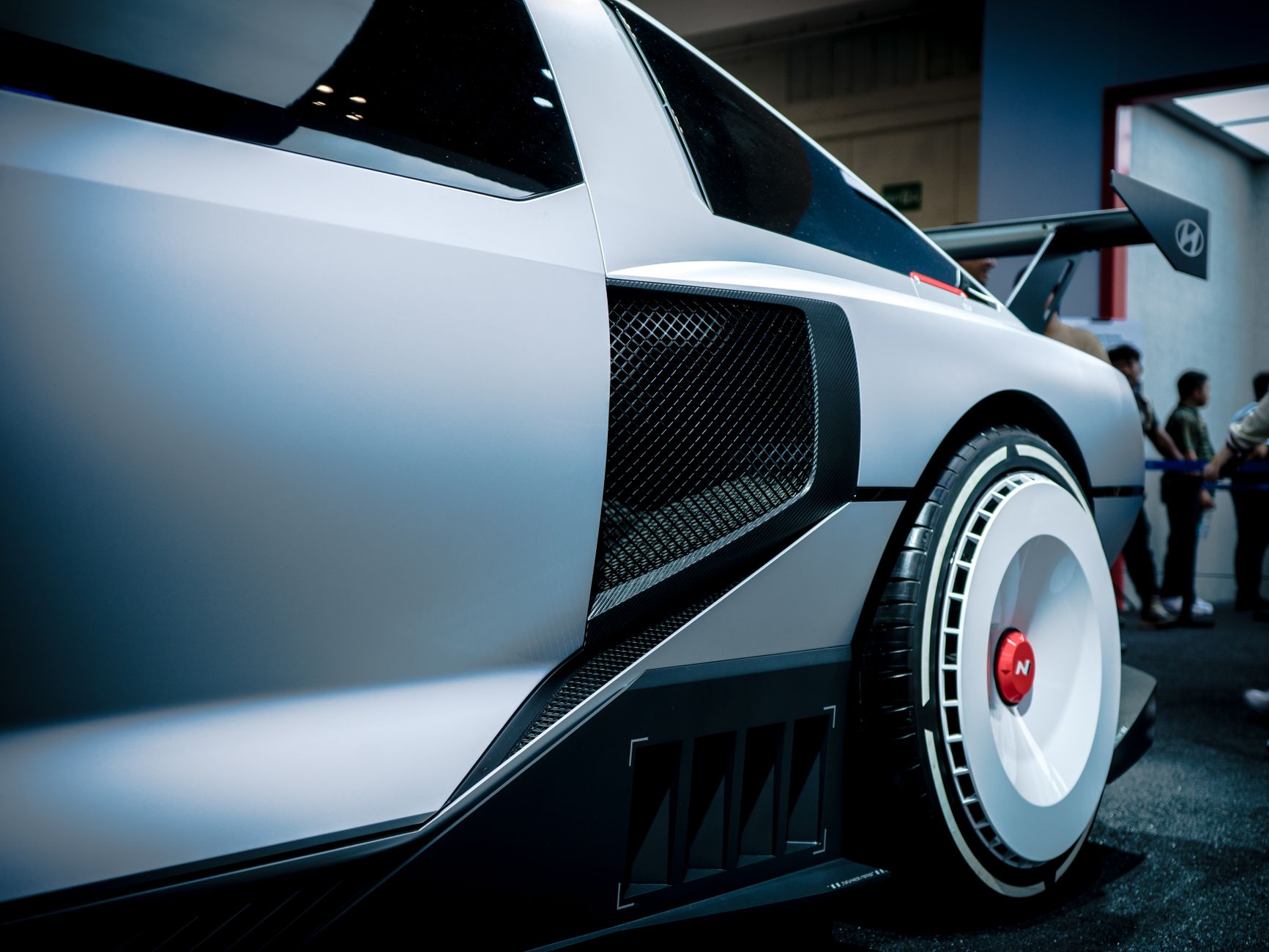 Ilustrasi: Close-up of a Hyundai concept car showcased in an indoor exhibition with modern design details.