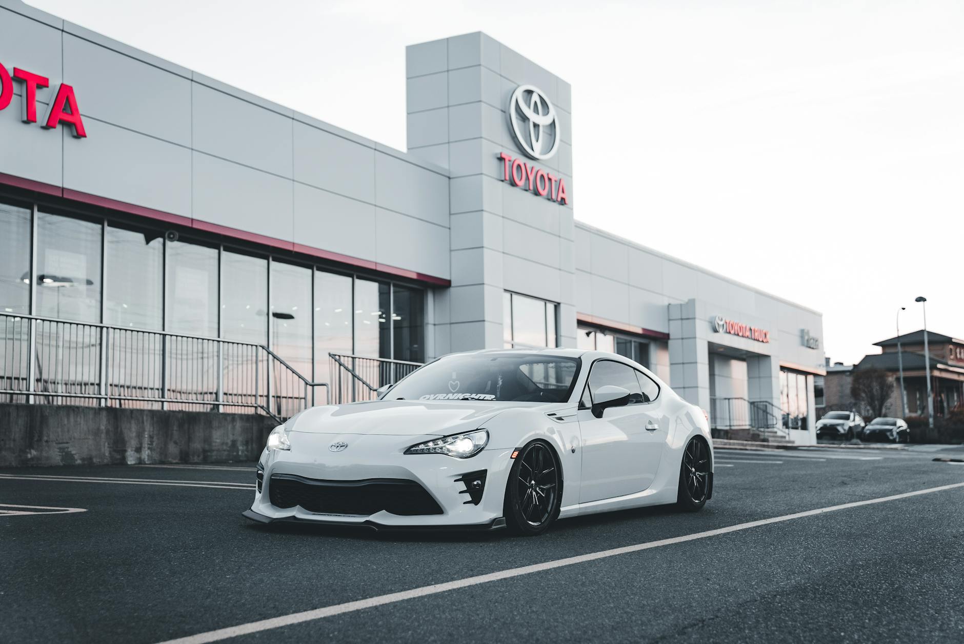 Ilustrasi: White Toyota sports car parked at a dealership, showcasing style and performance.