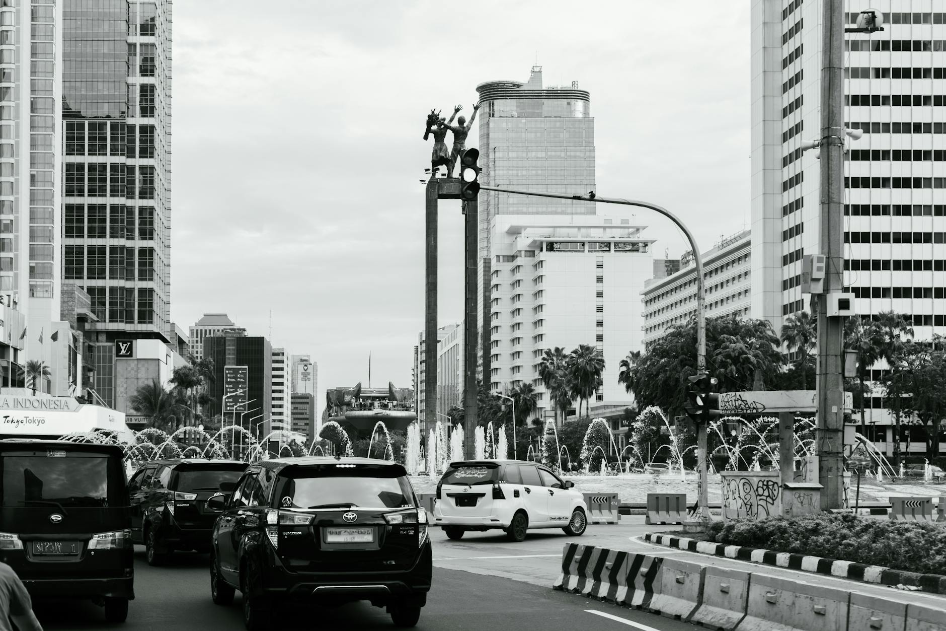 Ilustrasi: Black and white view of a busy Jakarta street with skyscrapers and vehicles.