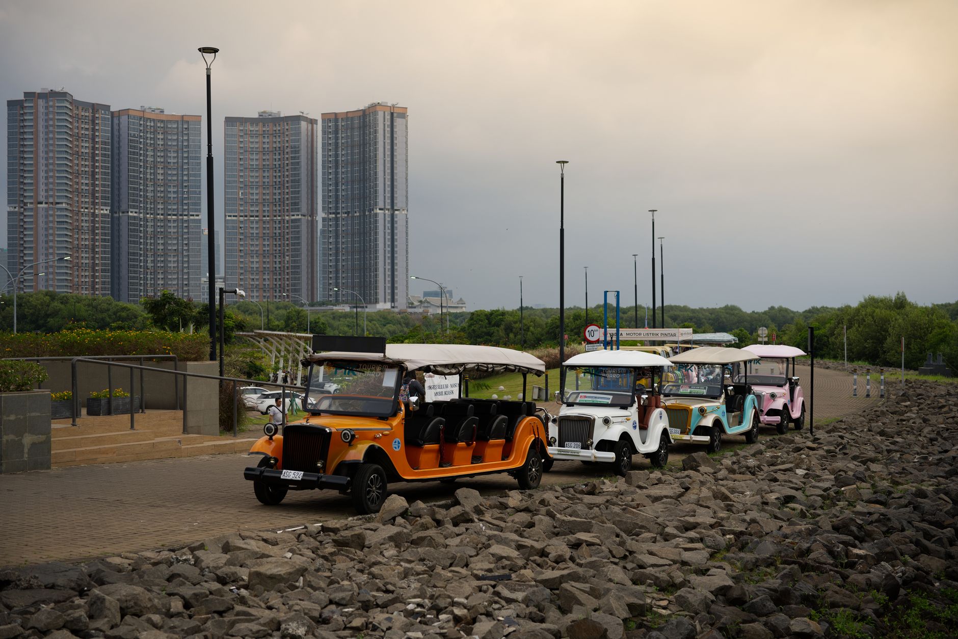 Ilustrasi: Bright tuk tuks lined up against Jakarta's modern skyscrapers, showcasing urban vibrancy.