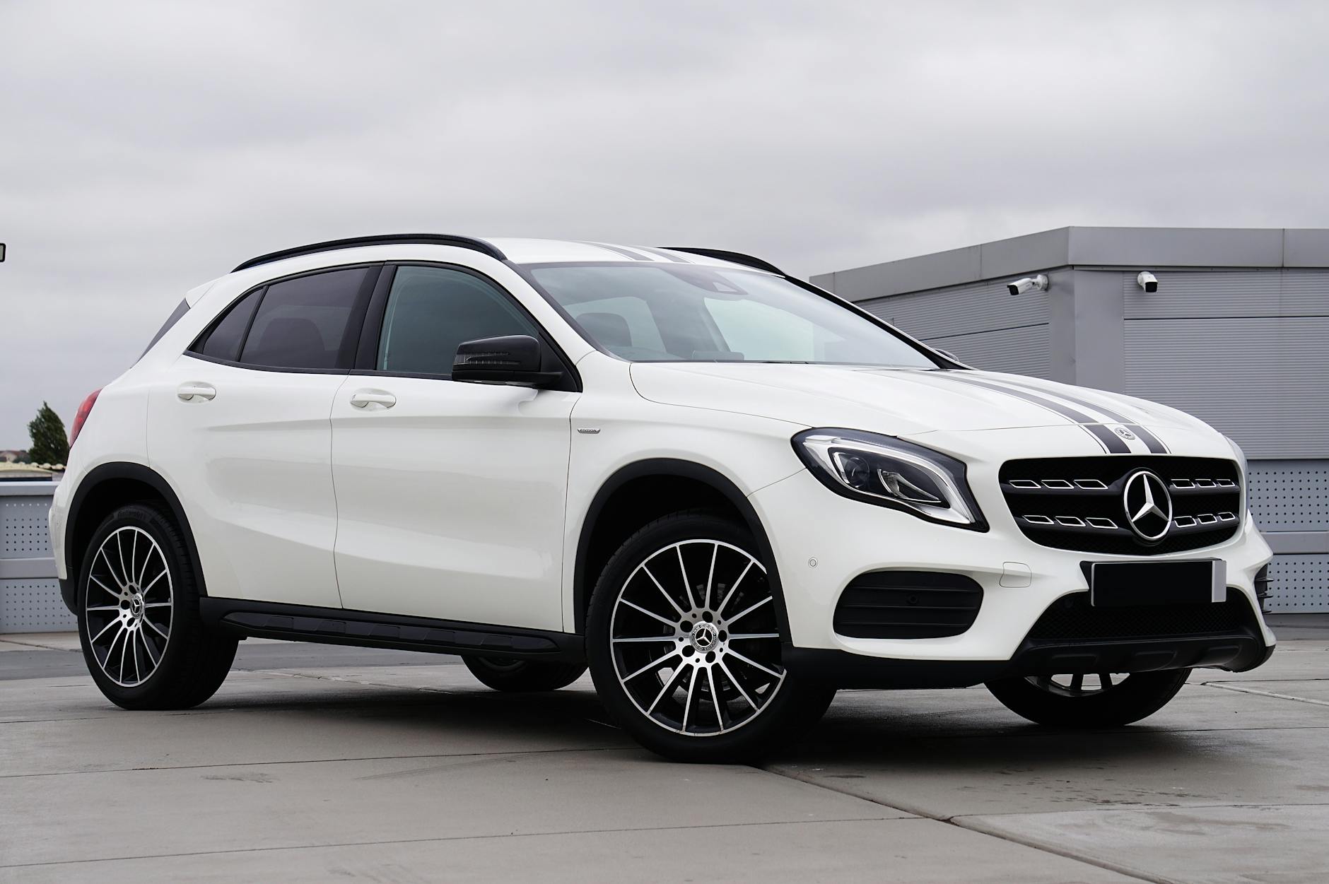 Ilustrasi: Luxury Mercedes-Benz GLA SUV in white parked outdoors showcasing modern design.