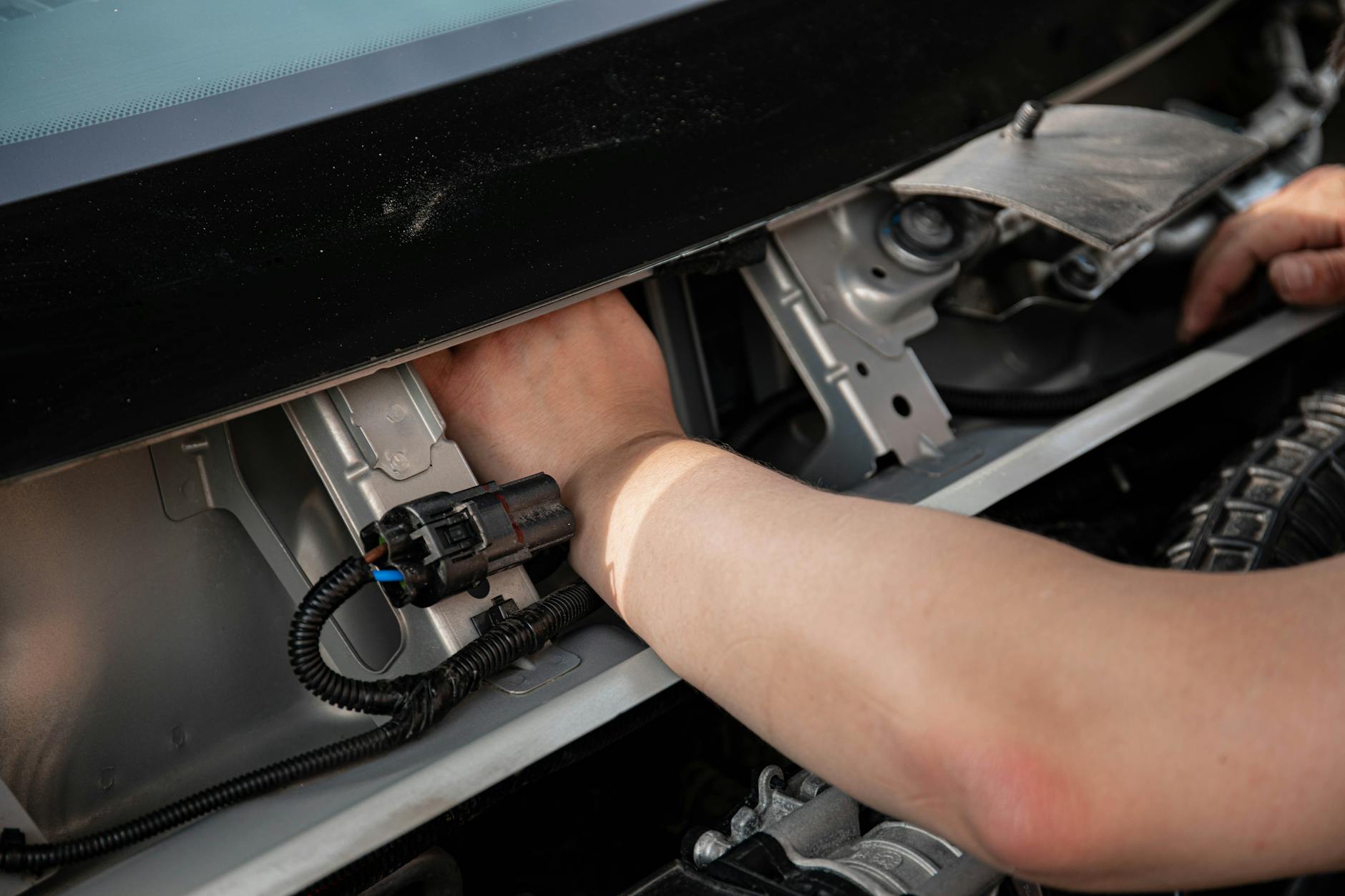 Ilustrasi: Close-up of mechanic hands repairing car electrical system, showcasing skill and precision.