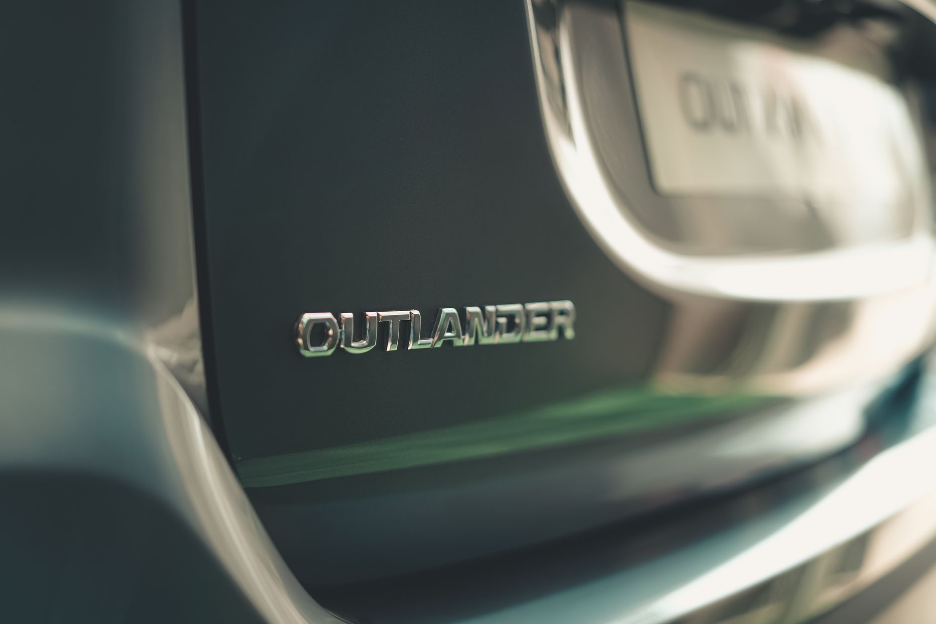 Ilustrasi: Detailed shot of Mitsubishi Outlander emblem on car rear, showcasing brand identity.