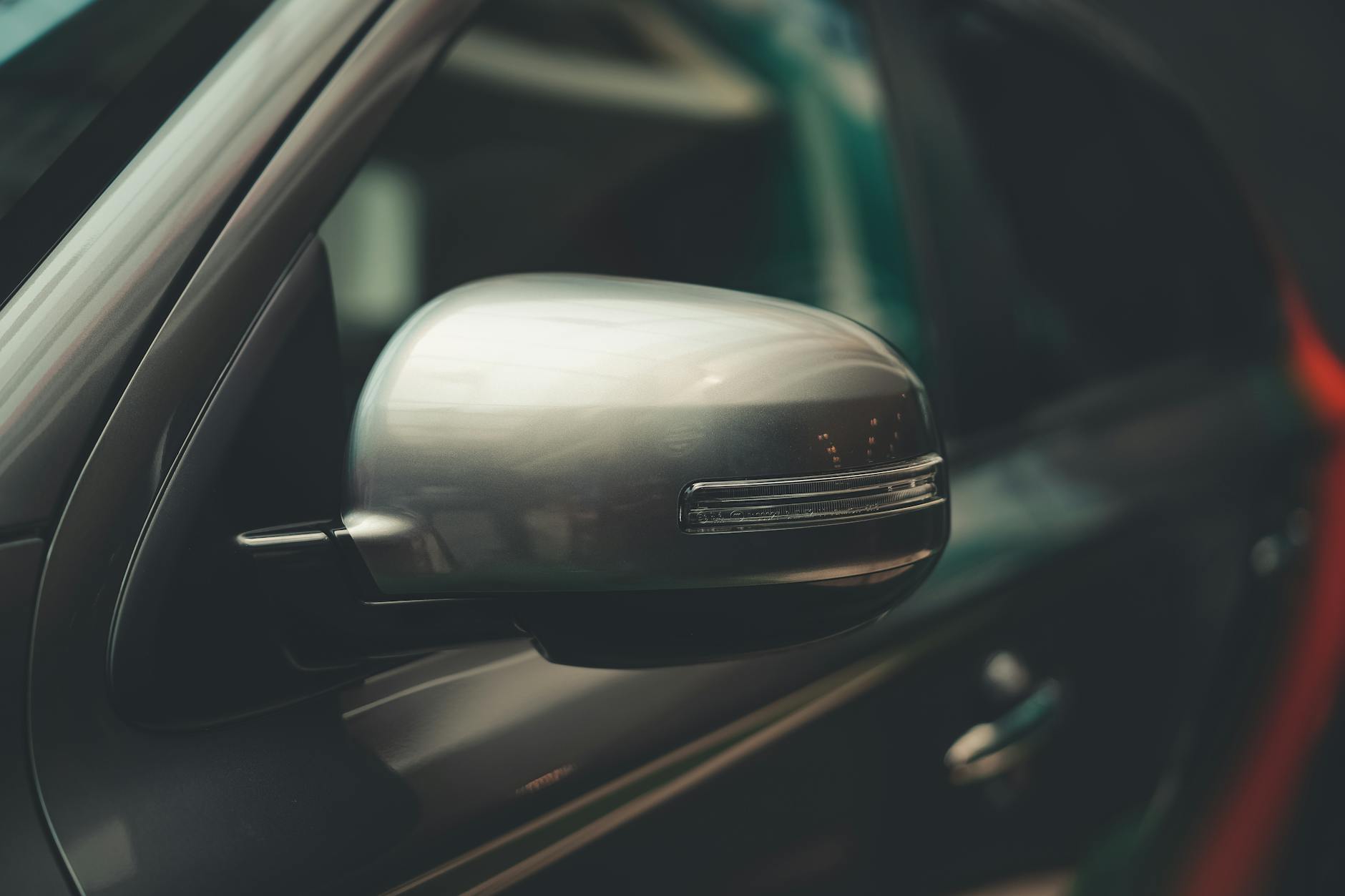 Ilustrasi: A detailed close-up of a car's chrome side mirror, showcasing modern design.