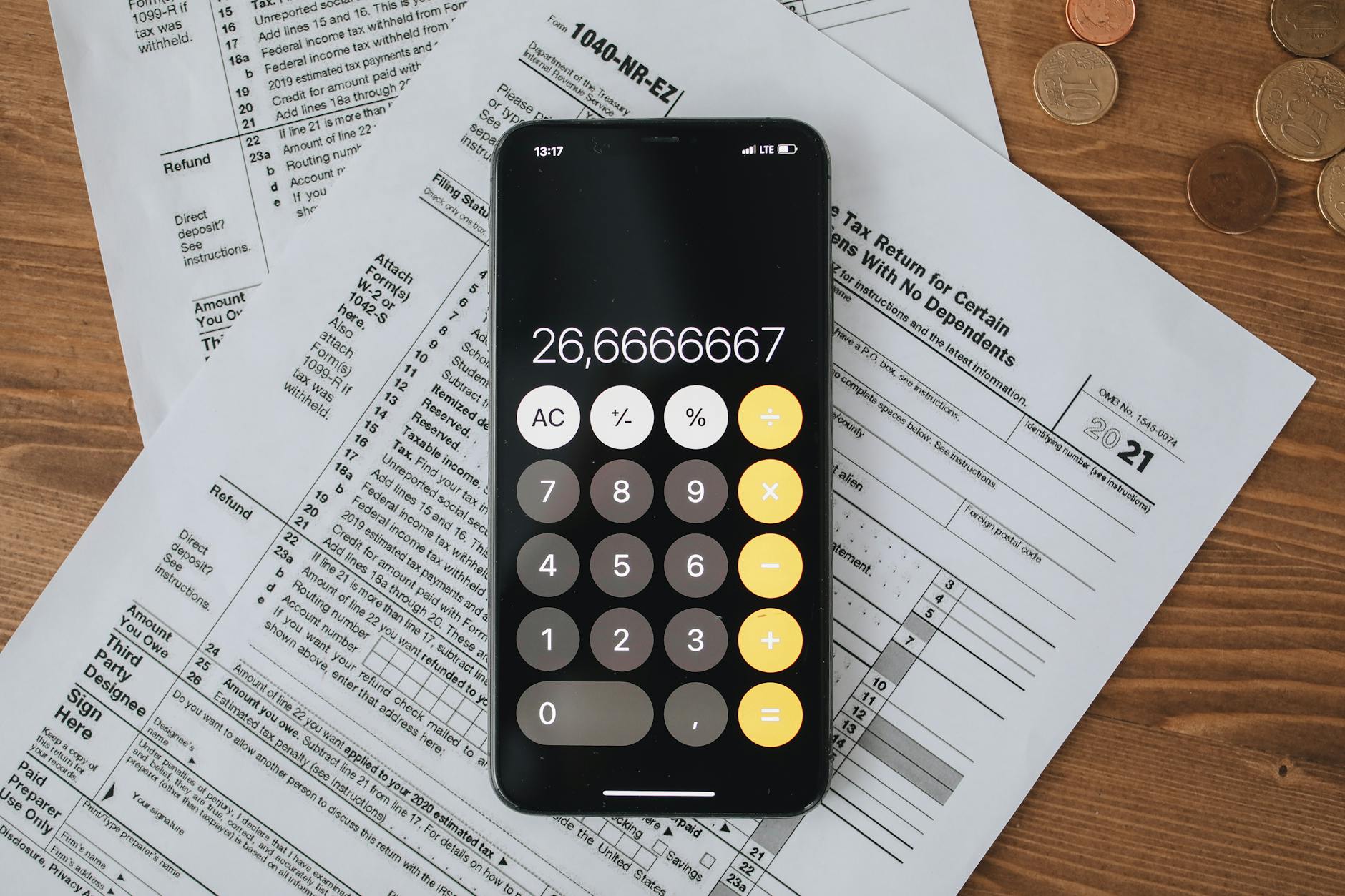 Ilustrasi: Mobile calculator app on tax documents, highlighting financial calculations and tax preparation.