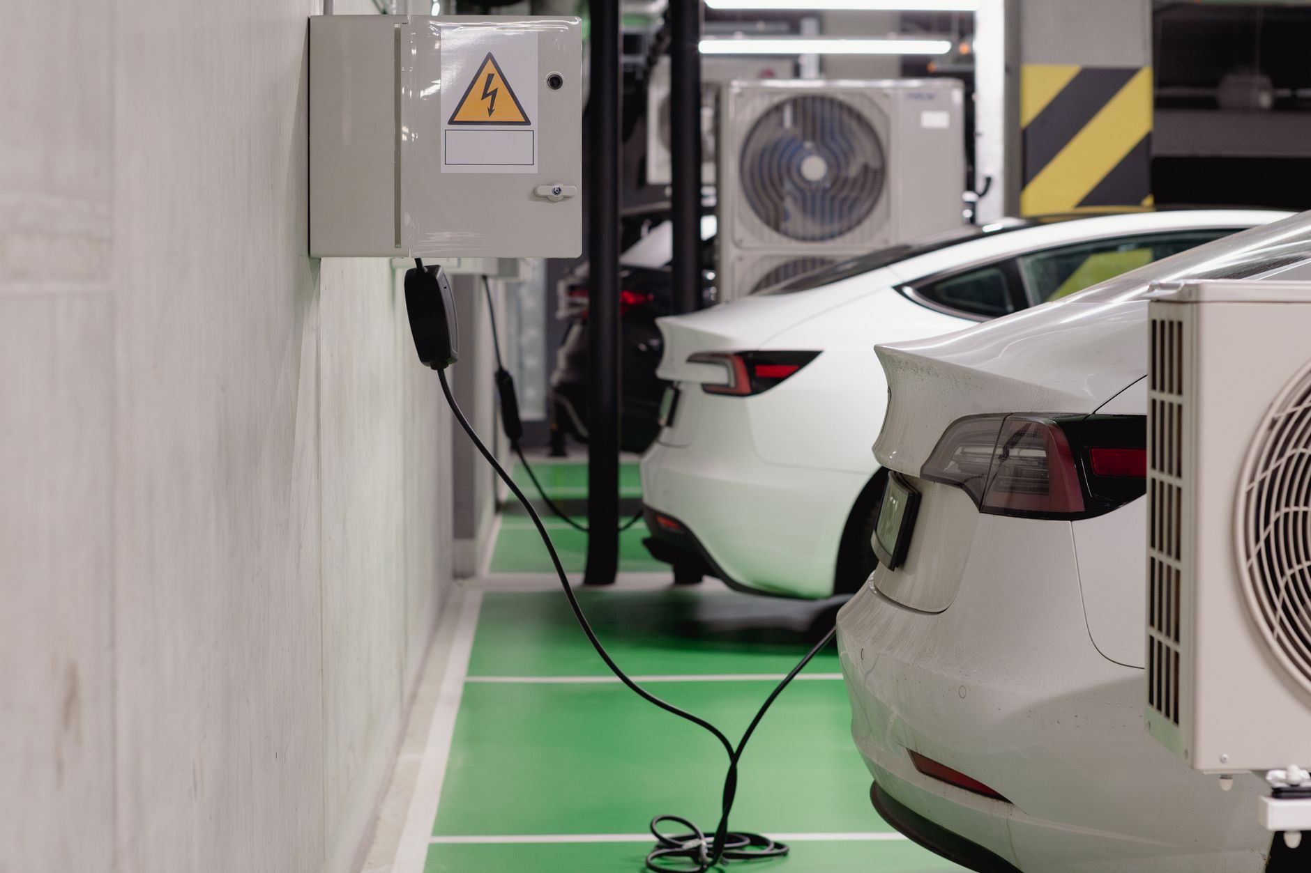 Ilustrasi: Electric vehicles charging at an indoor station in a modern underground garage.