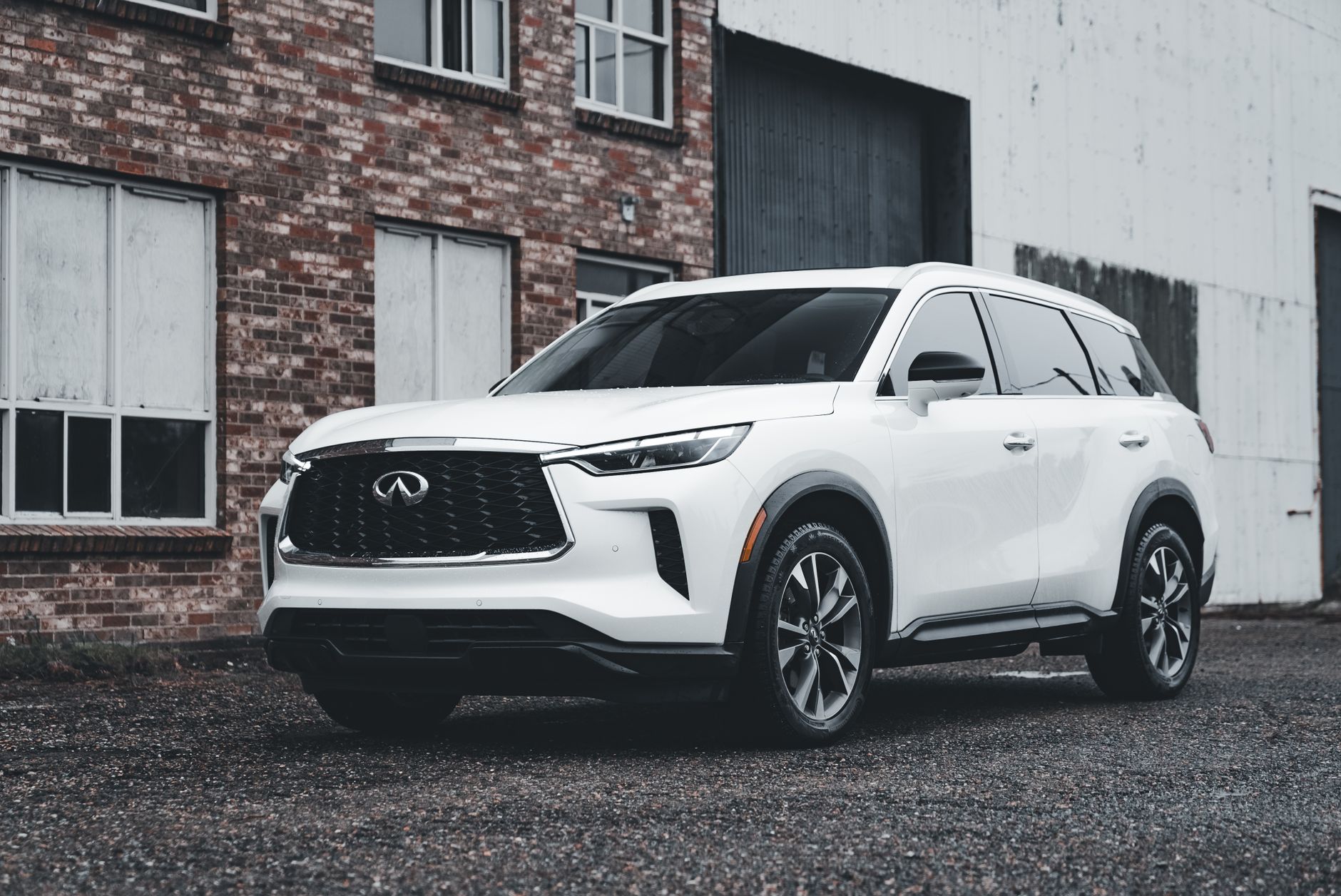 Ilustrasi: White luxury SUV parked outdoors in front of a brick building, showcasing modern automotive design.