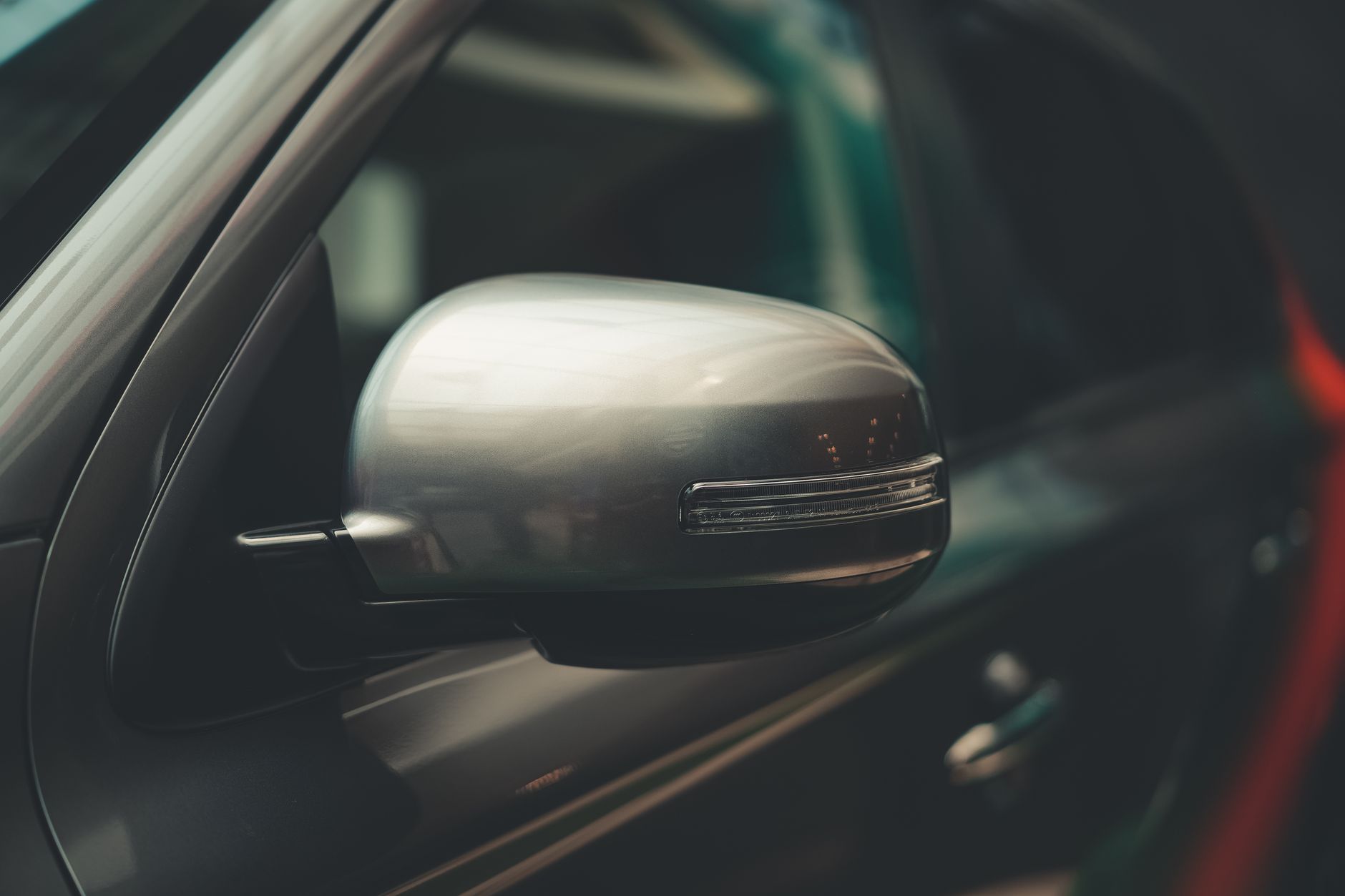 Ilustrasi: A detailed close-up of a car's chrome side mirror, showcasing modern design.