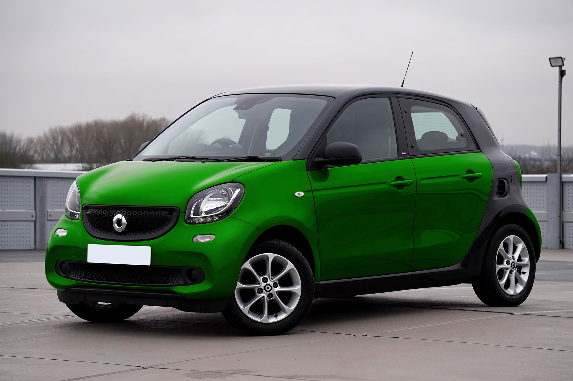 Ilustrasi: A green compact urban car parked outdoors, perfect for city driving. Modern and stylish design.