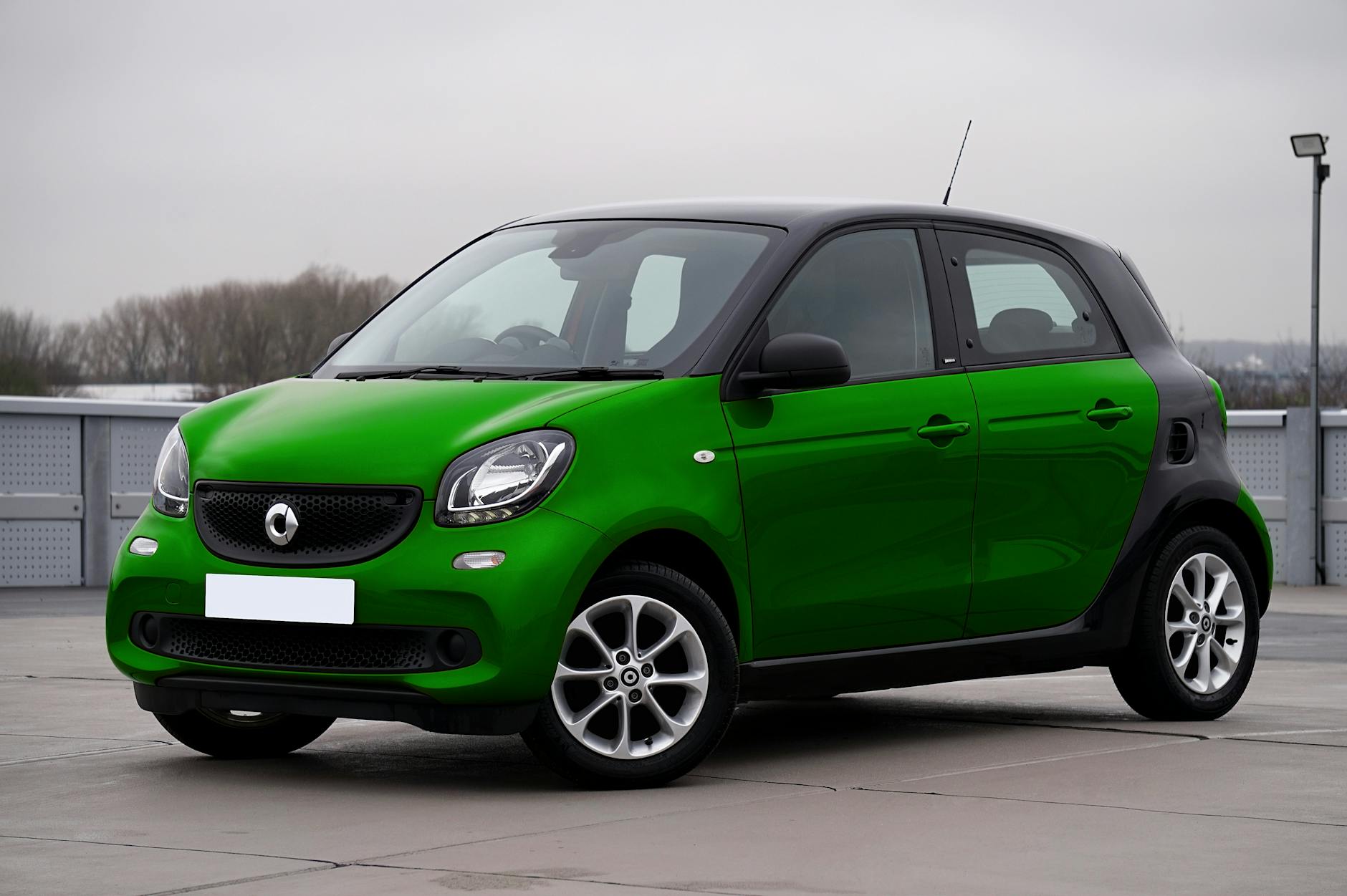 Ilustrasi: A green compact urban car parked outdoors, perfect for city driving. Modern and stylish design.