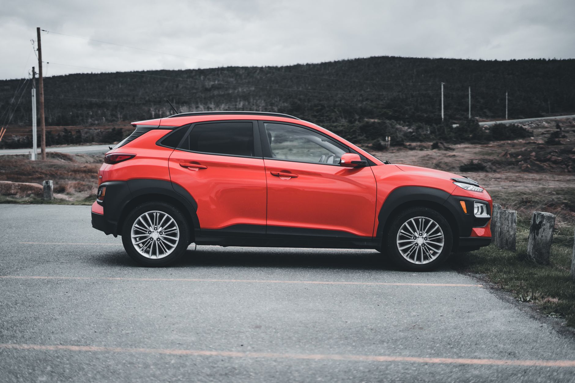Ilustrasi: Red SUV parked outdoors on a cloudy day, showcasing sleek design and vibrant color.