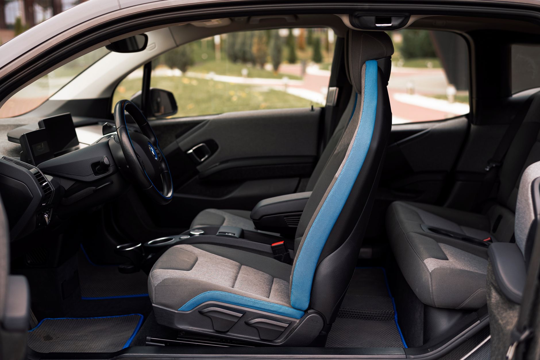 Ilustrasi: A sleek interior of a modern car showcasing the front and rear seats and steering wheel details.