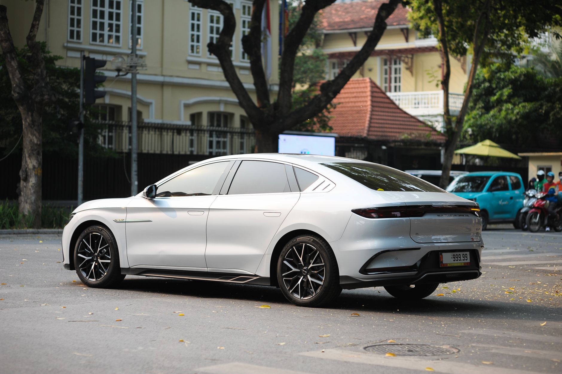 Ilustrasi: Sleek white electric car parked on a city street with classic buildings in the background.